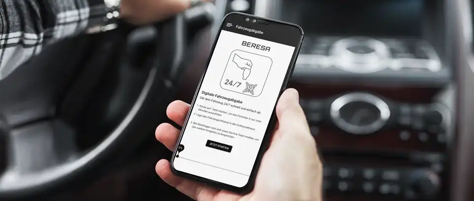 Ein Autofahrer nutzt die nachhaltig mobiloptimierte App der 24h-Fahrzeugabgabe aus seinem Fahrzeug heraus